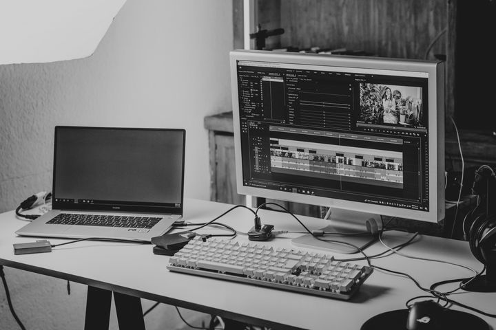 Dual-screen video editing workstation showing timeline software on desktop computer